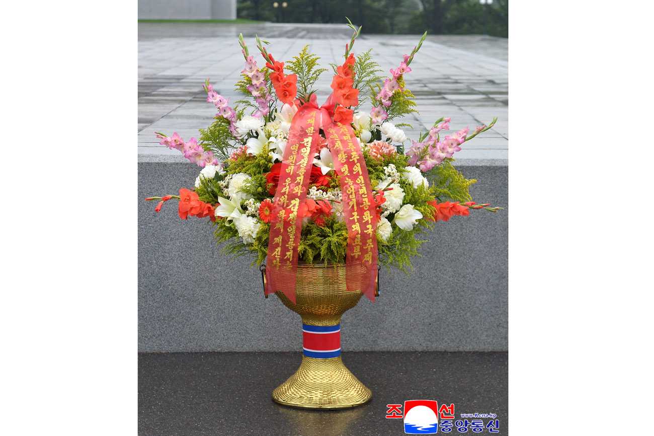 Floral baskets laid before bronze statues of great leaders Kim Il Sung and Kim Jong Il