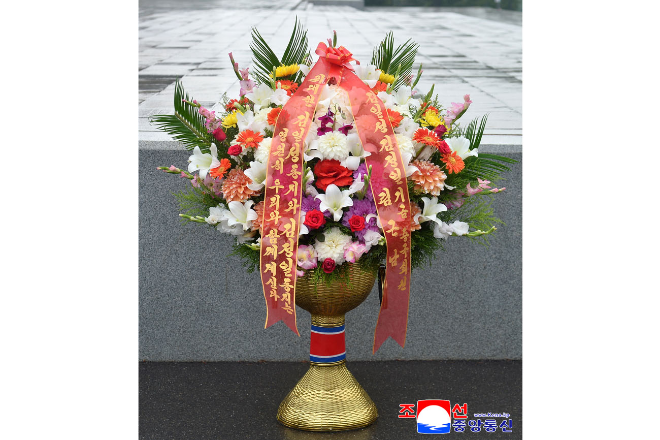 Floral baskets laid before bronze statues of great leaders Kim Il Sung and Kim Jong Il