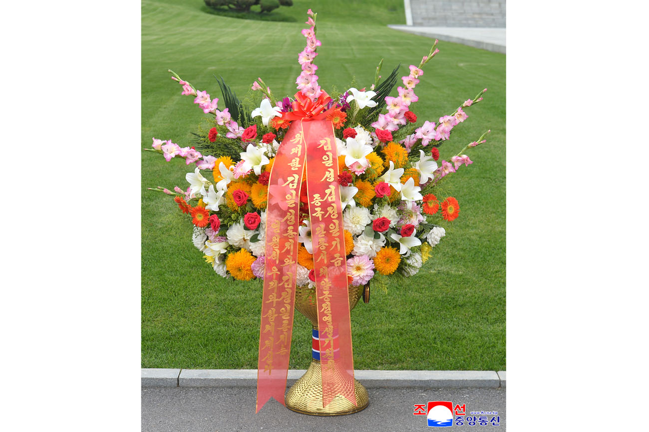 Floral baskets sent to bronze statues of great leaders Kim Il Sung and Kim Jong Il