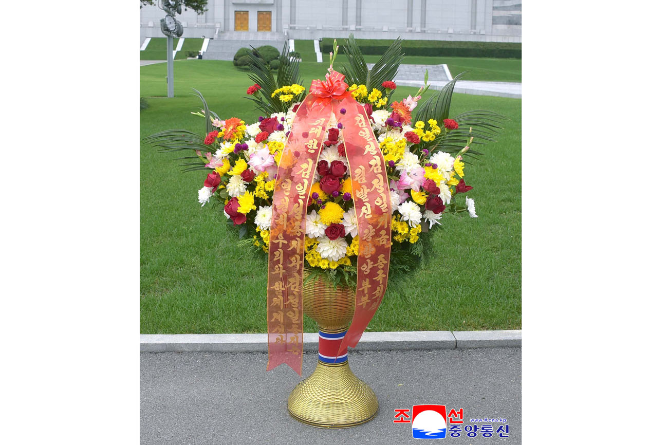 위대한 수령 김일성동지와 위대한 령도자 김정일동지의  동상에 김일성김정일기금 회원들이 꽃바구니를 드리였다